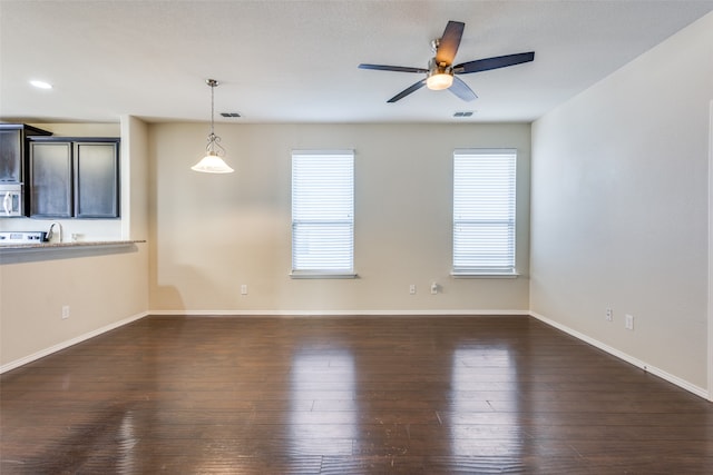 unfurnished room featuring dark wood-type flooring and ceiling fan