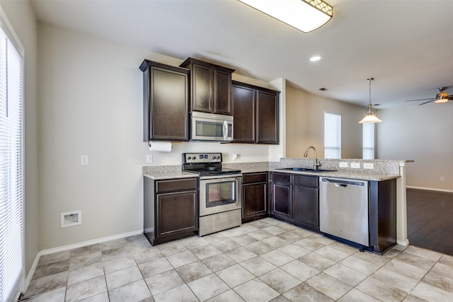 kitchen featuring sink, kitchen peninsula, appliances with stainless steel finishes, ceiling fan, and hanging light fixtures