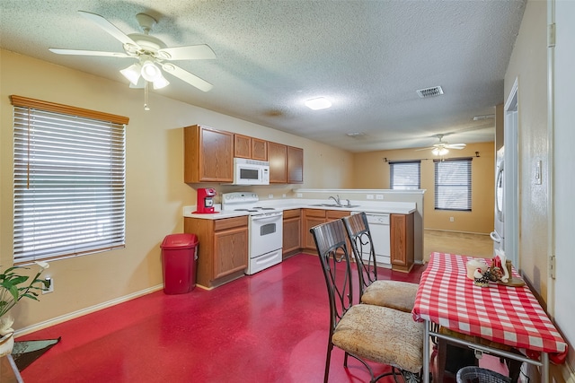 kitchen featuring white appliances, ceiling fan, a textured ceiling, and sink