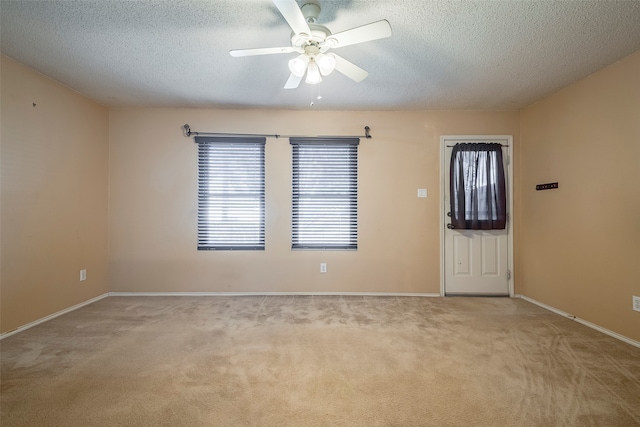 carpeted spare room with a textured ceiling and ceiling fan