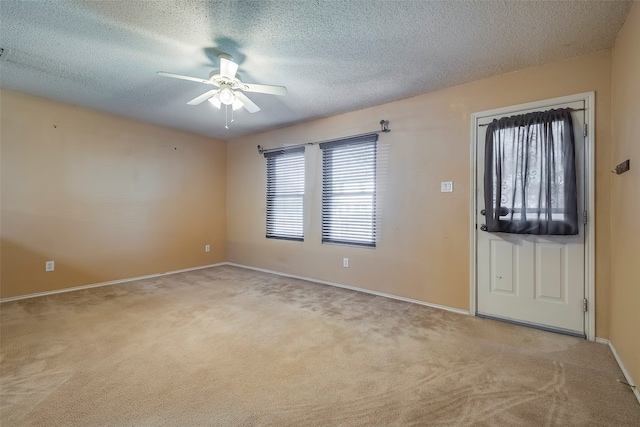 entryway with a textured ceiling, light colored carpet, and ceiling fan