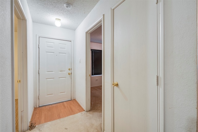 doorway with wood-type flooring and a textured ceiling