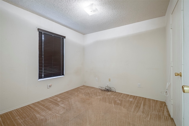 unfurnished room with a textured ceiling and light carpet