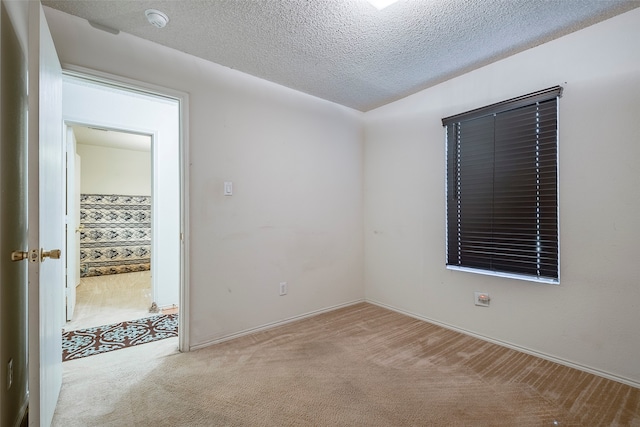 carpeted empty room with a textured ceiling