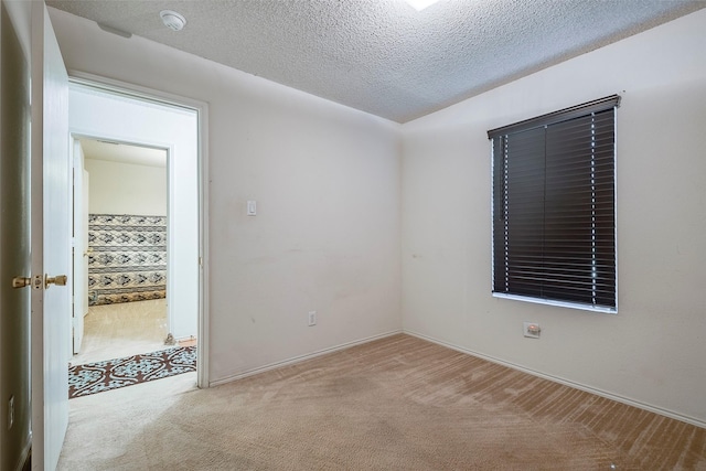 carpeted spare room featuring a textured ceiling