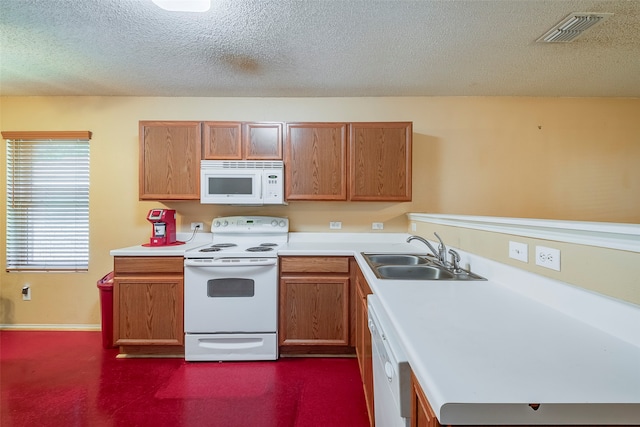 kitchen featuring sink, white appliances, and a textured ceiling