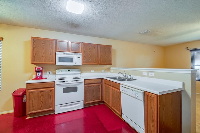 kitchen featuring sink, a textured ceiling, white appliances, and kitchen peninsula