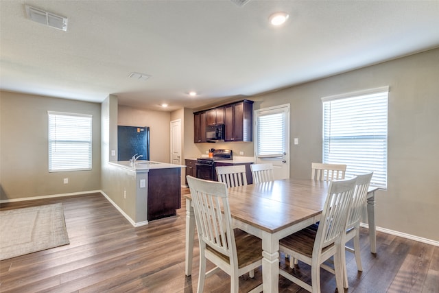 dining space with a wealth of natural light, sink, and dark wood-type flooring