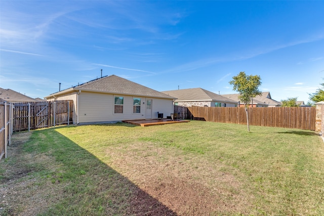 rear view of property featuring a lawn and a wooden deck