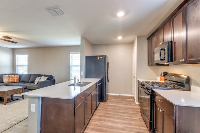 kitchen with light wood-type flooring, dark brown cabinets, ceiling fan, sink, and black appliances