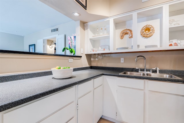 kitchen featuring white cabinetry and sink