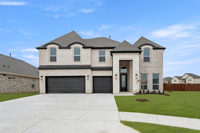 french provincial home with a garage and a front lawn