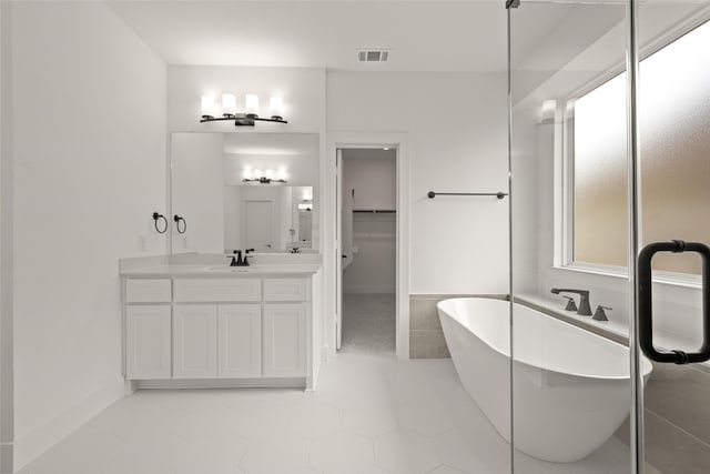 bathroom featuring vanity, a washtub, and tile patterned flooring