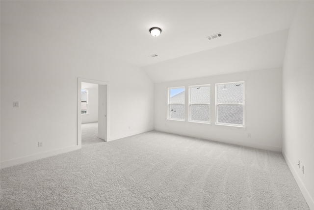 spare room with light carpet and lofted ceiling