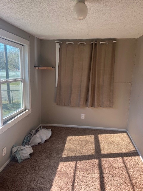 carpeted spare room with a textured ceiling