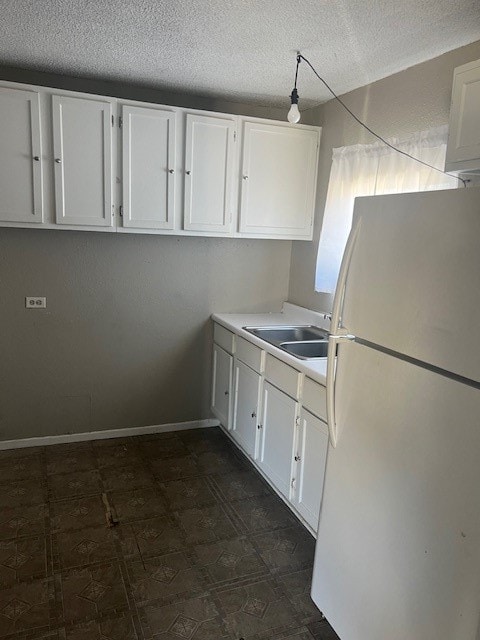 kitchen featuring white cabinetry, sink, and white refrigerator