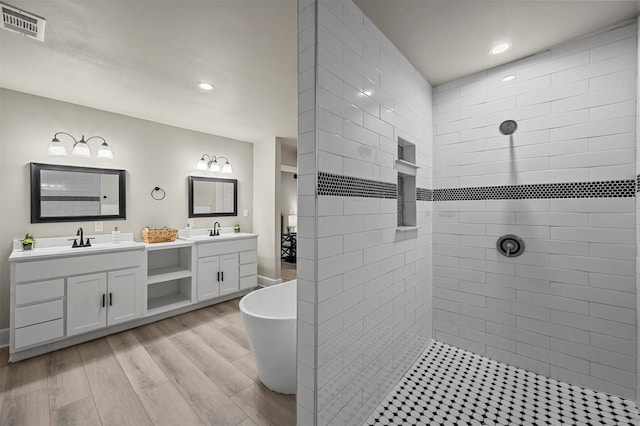 bathroom with hardwood / wood-style floors, vanity, and separate shower and tub