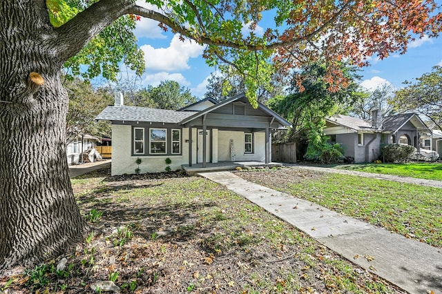 ranch-style house featuring covered porch and a front yard