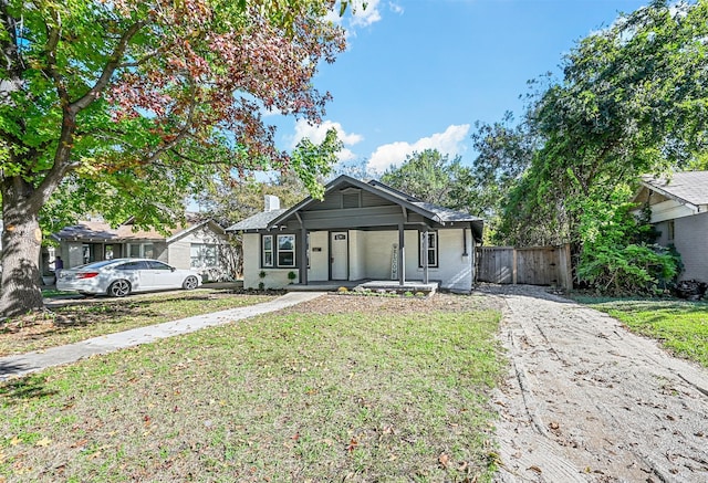 view of front of house featuring covered porch and a front yard