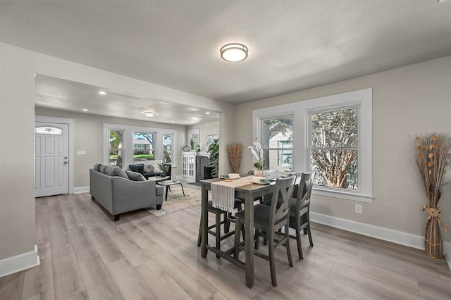 dining room featuring a textured ceiling and light hardwood / wood-style floors