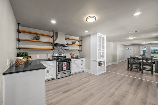 kitchen featuring white cabinets, gas range, light hardwood / wood-style floors, and custom range hood