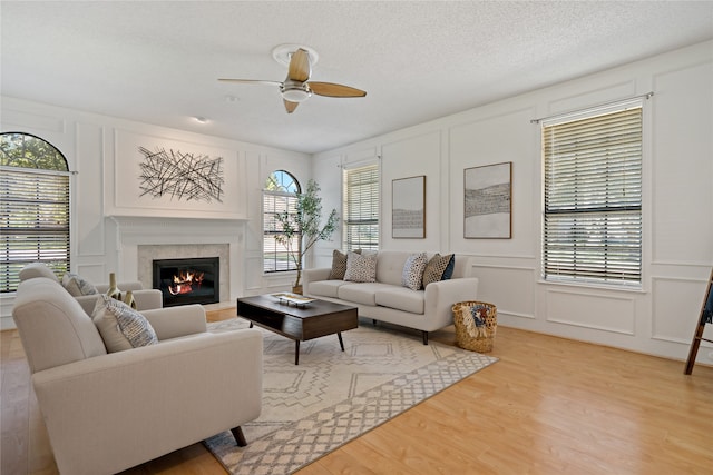 living room featuring a textured ceiling, hardwood / wood-style flooring, and ceiling fan