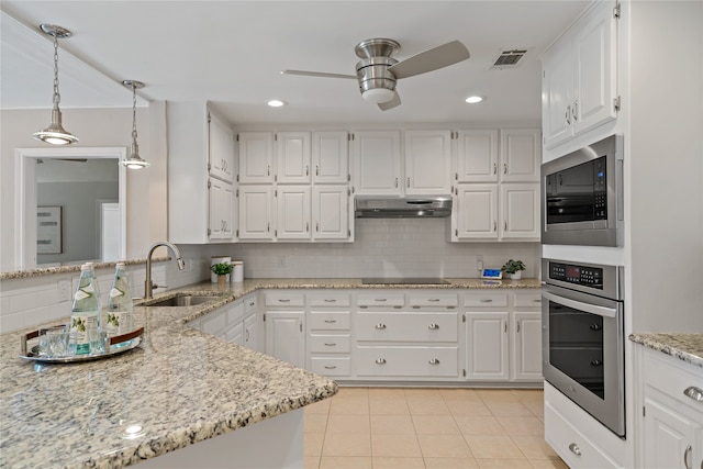 kitchen featuring appliances with stainless steel finishes, tasteful backsplash, sink, white cabinetry, and hanging light fixtures