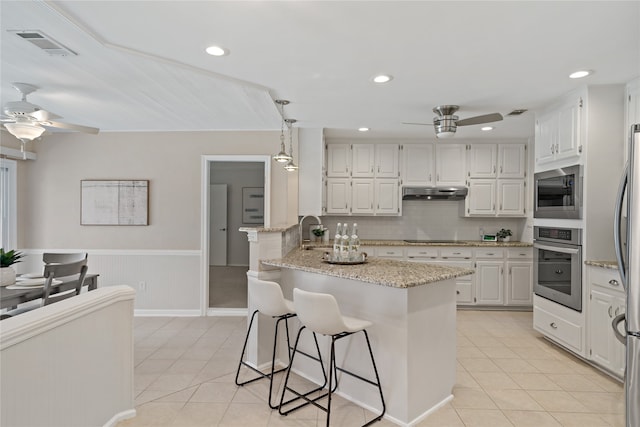 kitchen featuring tasteful backsplash, stainless steel appliances, pendant lighting, white cabinetry, and light tile patterned flooring