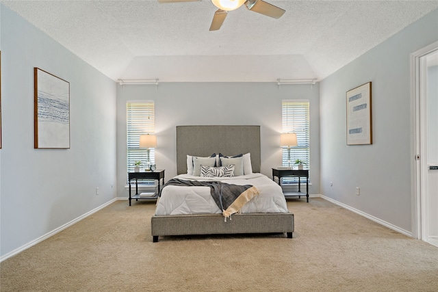 carpeted bedroom featuring a textured ceiling, ceiling fan, and lofted ceiling