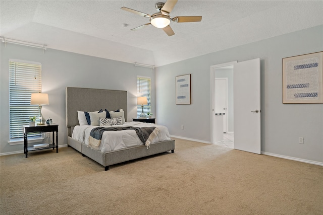 bedroom with vaulted ceiling, ceiling fan, light colored carpet, and a textured ceiling