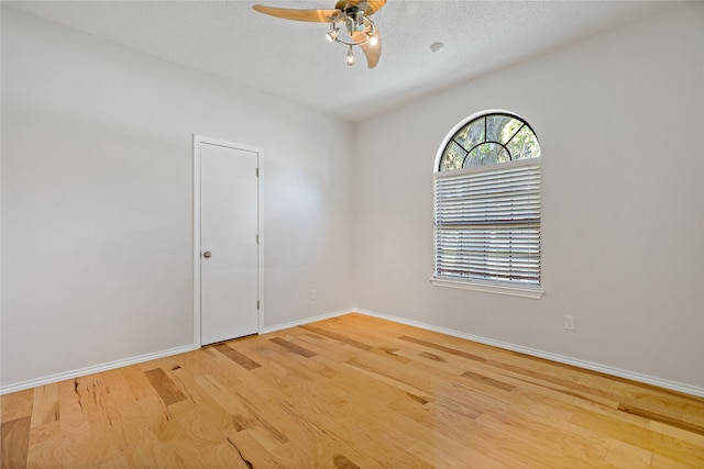 unfurnished room featuring ceiling fan, light wood-type flooring, and a textured ceiling