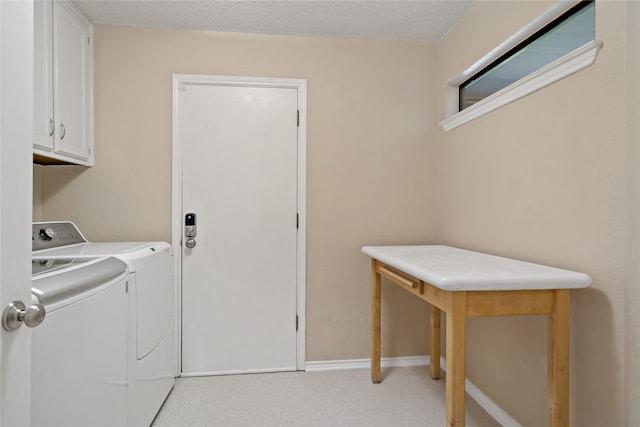 washroom with separate washer and dryer, cabinets, and a textured ceiling