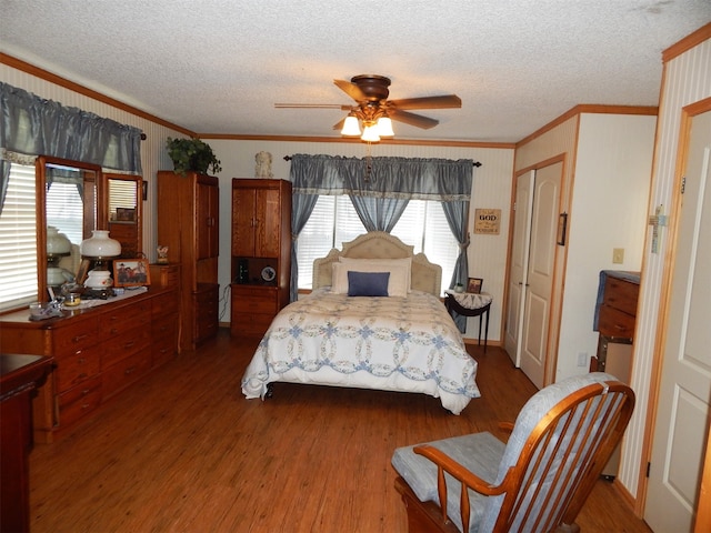 bedroom with ornamental molding, hardwood / wood-style floors, and ceiling fan