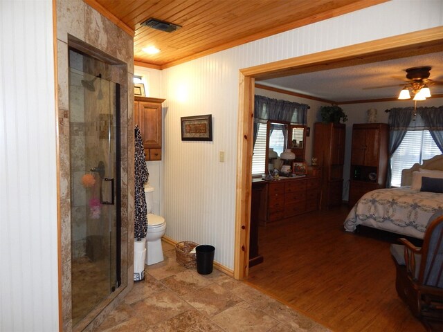 interior space with toilet, hardwood / wood-style flooring, ceiling fan, crown molding, and a shower with shower door