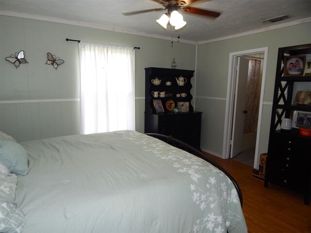 bedroom with ceiling fan, wood-type flooring, a textured ceiling, and crown molding