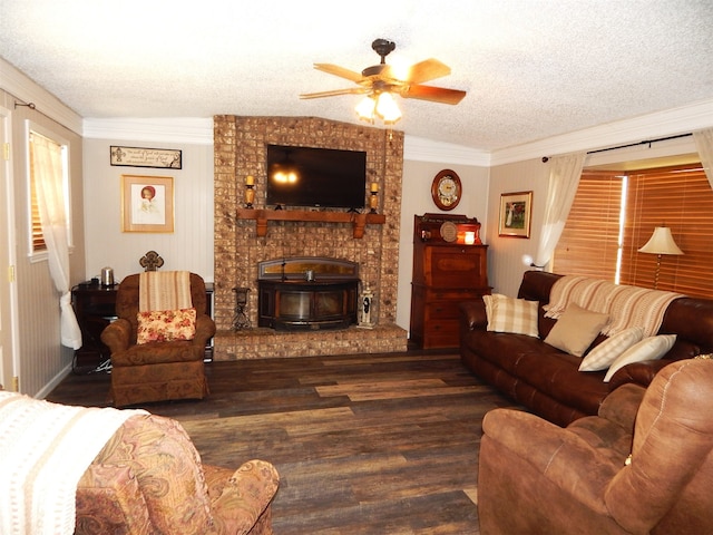 living room with dark wood-type flooring, ceiling fan, a textured ceiling, and ornamental molding