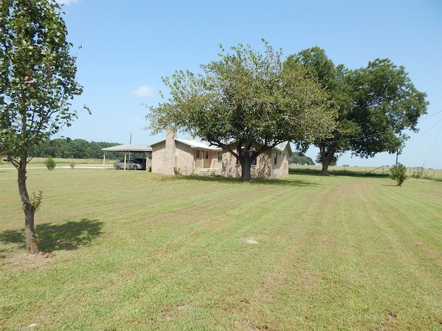 view of yard with a rural view and a carport