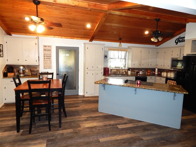 kitchen featuring white cabinetry, black appliances, dark stone countertops, lofted ceiling, and dark hardwood / wood-style flooring