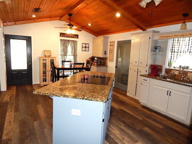 kitchen with vaulted ceiling with beams, black electric stovetop, white cabinetry, dark hardwood / wood-style flooring, and sink