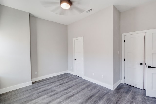 empty room featuring dark wood-type flooring and ceiling fan