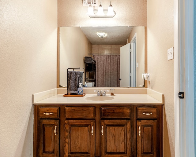 bathroom featuring a textured ceiling and vanity