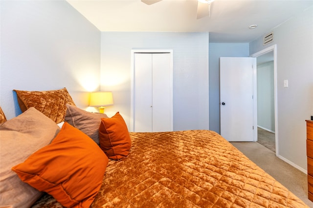 carpeted bedroom featuring ceiling fan and a closet