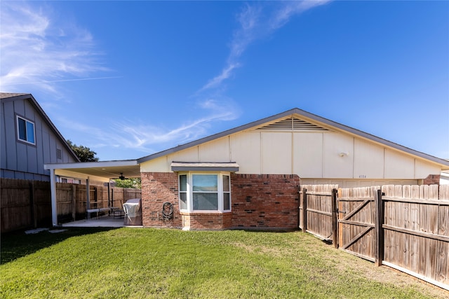 back of property with a patio and a lawn