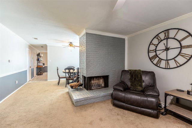 sitting room with ceiling fan, ornamental molding, a fireplace, and light carpet