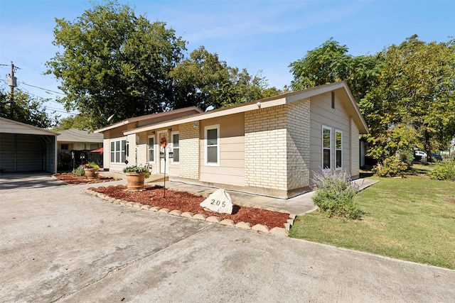 ranch-style home featuring a front lawn and a carport