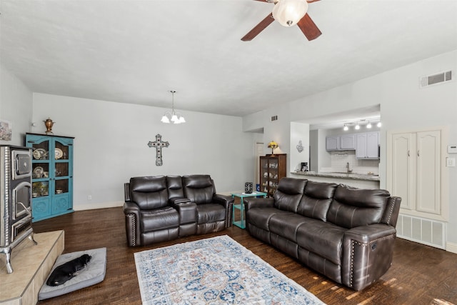 living room featuring dark wood-type flooring and ceiling fan with notable chandelier