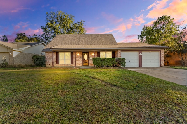 view of front of home with a garage and a yard