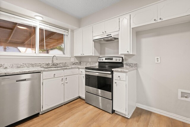 kitchen with white cabinetry, sink, appliances with stainless steel finishes, a textured ceiling, and light hardwood / wood-style flooring