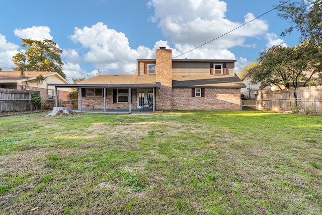 rear view of property with a lawn and a patio