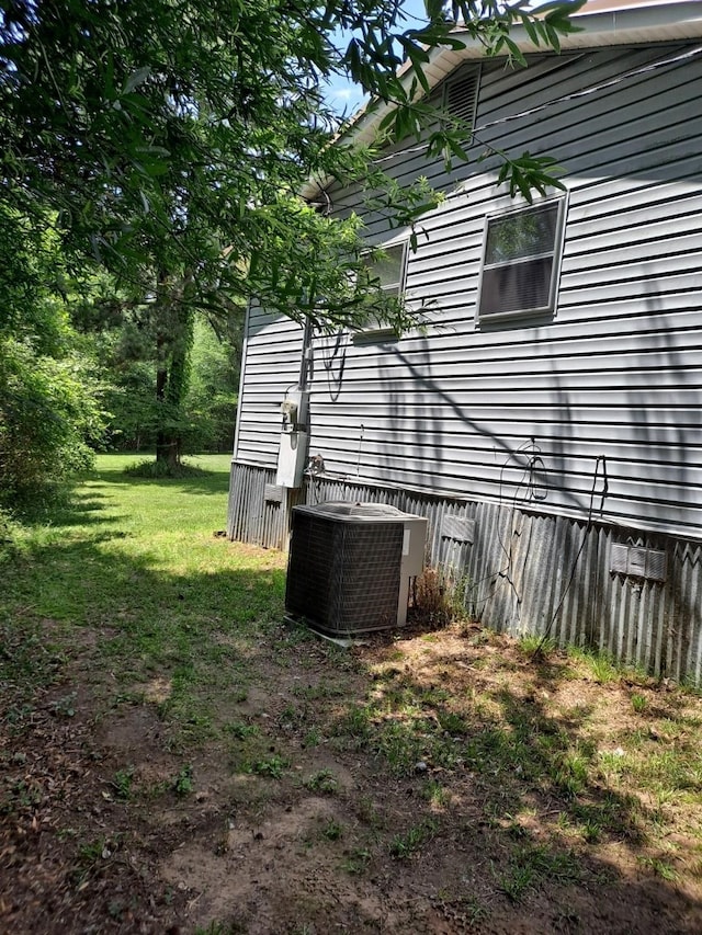 view of home's exterior with central AC and a lawn